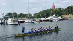 Team sitzt im Drachenboot vor der Inselkirche. Team sitzt im Drachenboot vor der Inselkirche.